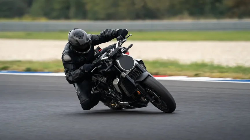 Motorkář zkouší náklon s kolínkem, oblíbená disciplína motorkářů.