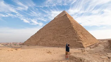 muž stojí u pyramidy