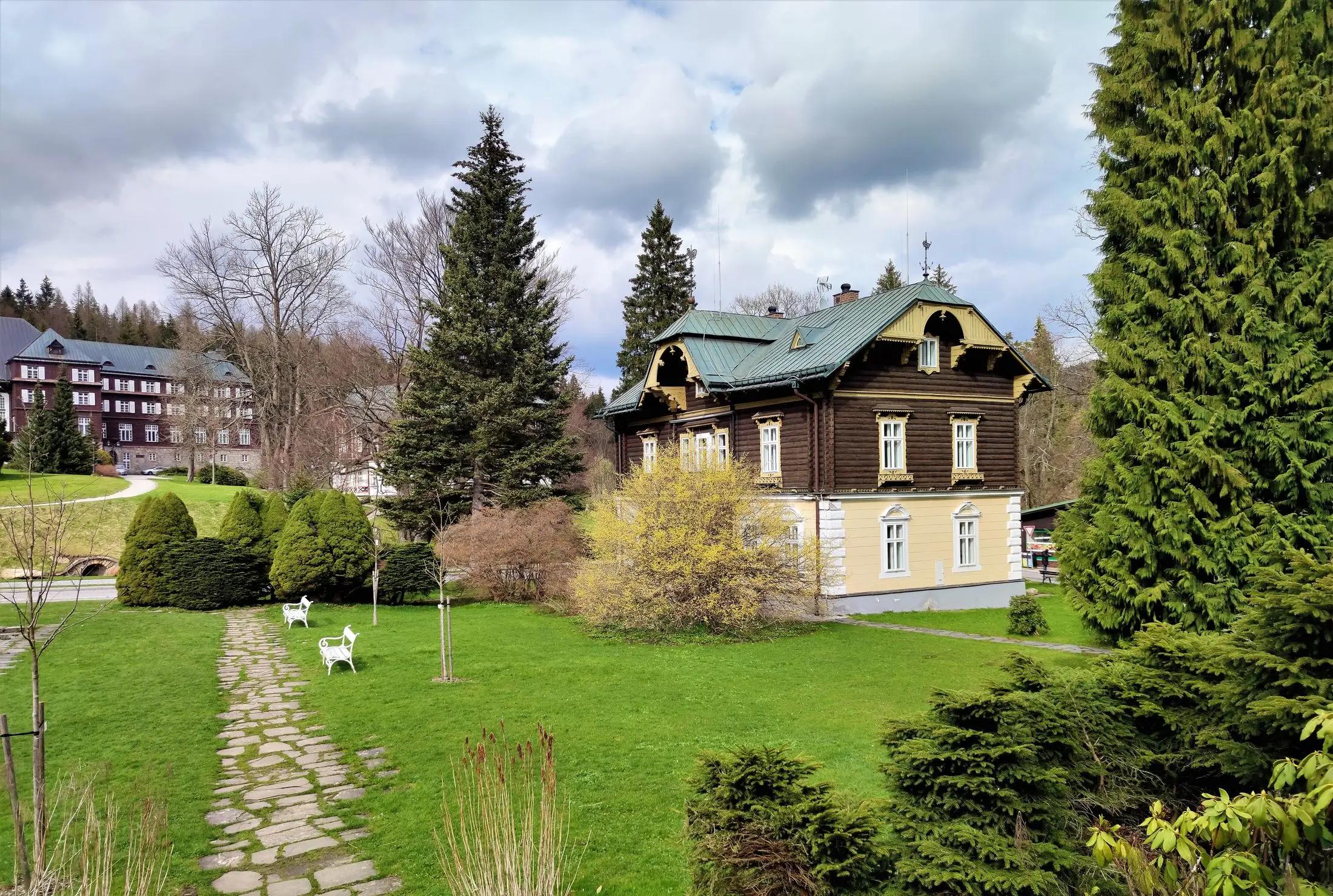 Vila Evžen v krásném prostředí Karlovy Studánky. V pozadí jde na levé straně vidět další zdejší budova.