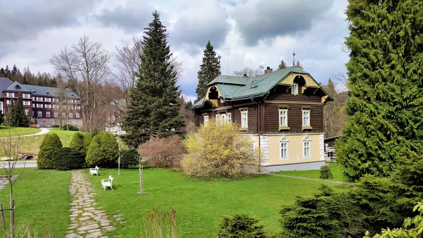 Vila Evžen v krásném prostředí Karlovy Studánky. V pozadí jde na levé straně vidět další zdejší budova.