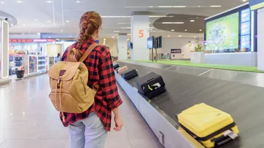 Žena čeká na kufr na letišti