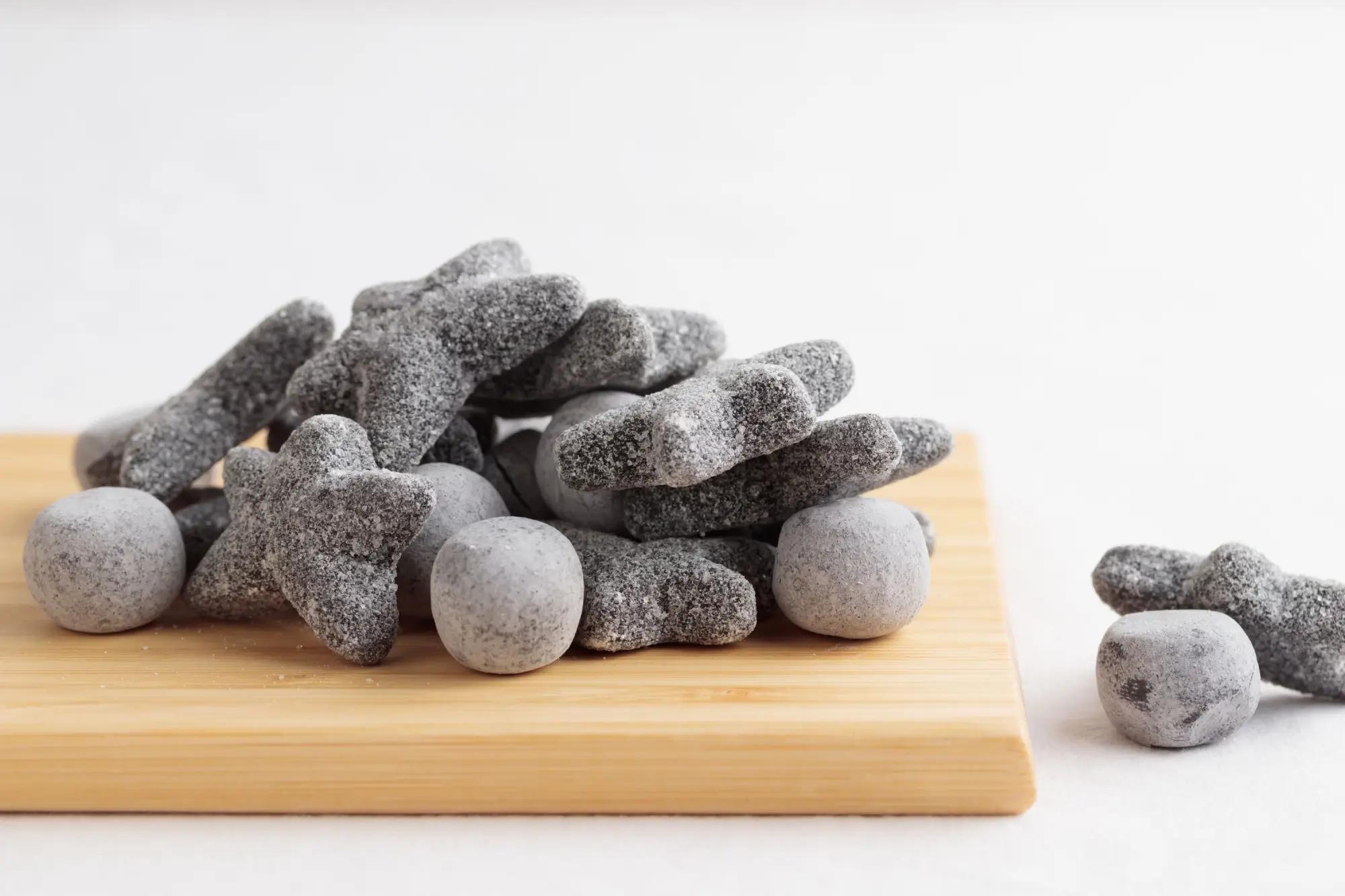 Slané lékořicové salmiakki na dřevěném prkénku 