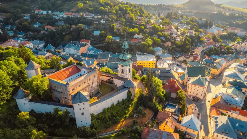Letecký pohled na město Banská Štiavnica. Na levé straně jde vidět Starý zámek, poté ostatní domy města a zeleň okolí.