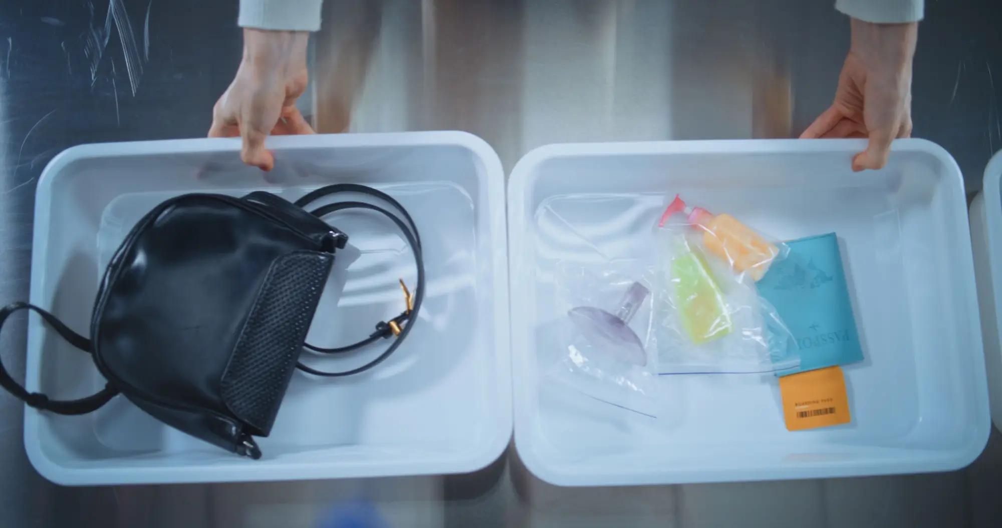 Osobní věci cestovatele v boxech při letištní bezpečnostní kontrole
