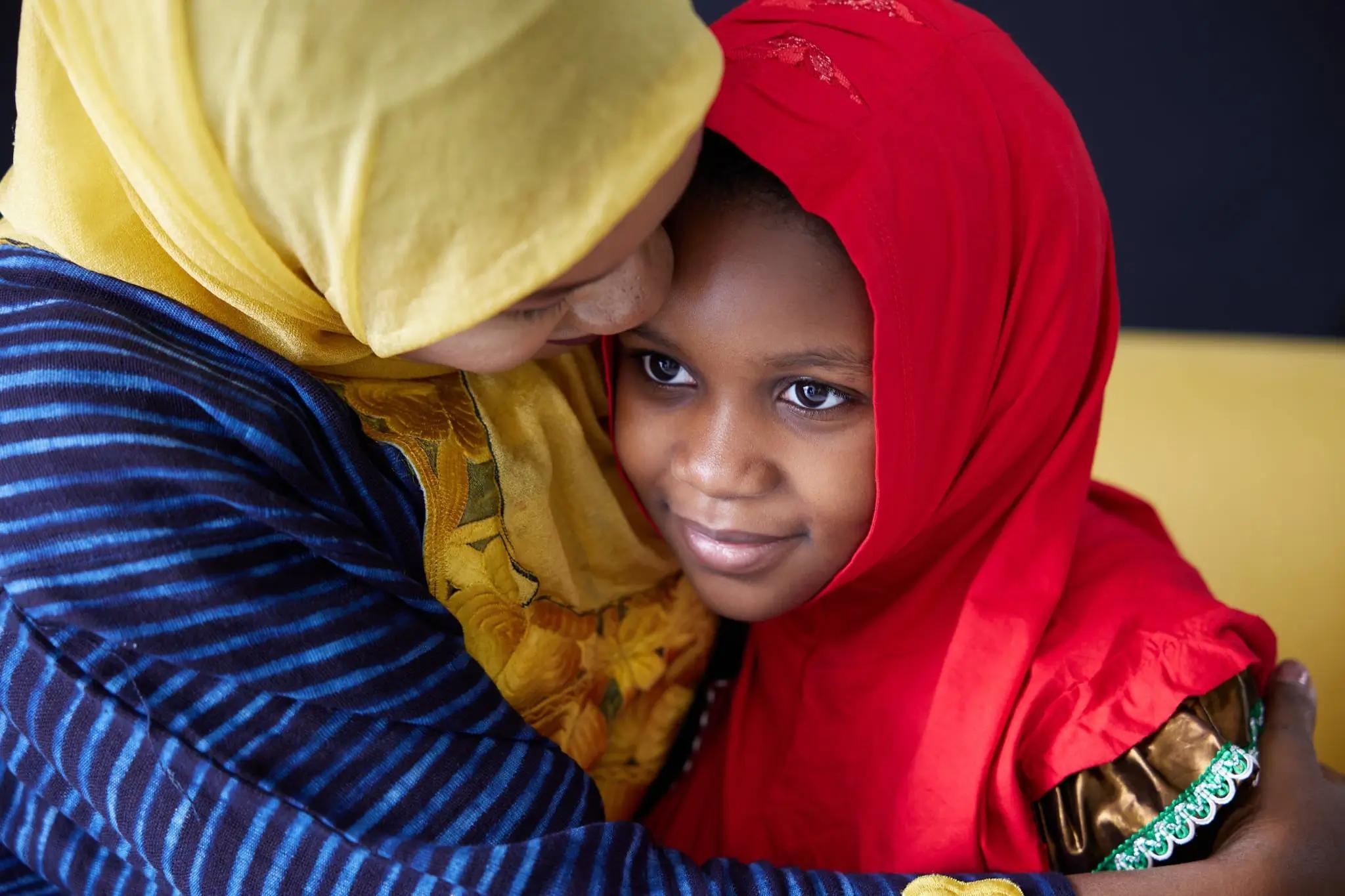 Muslimská matka objímající svou malou dceru.