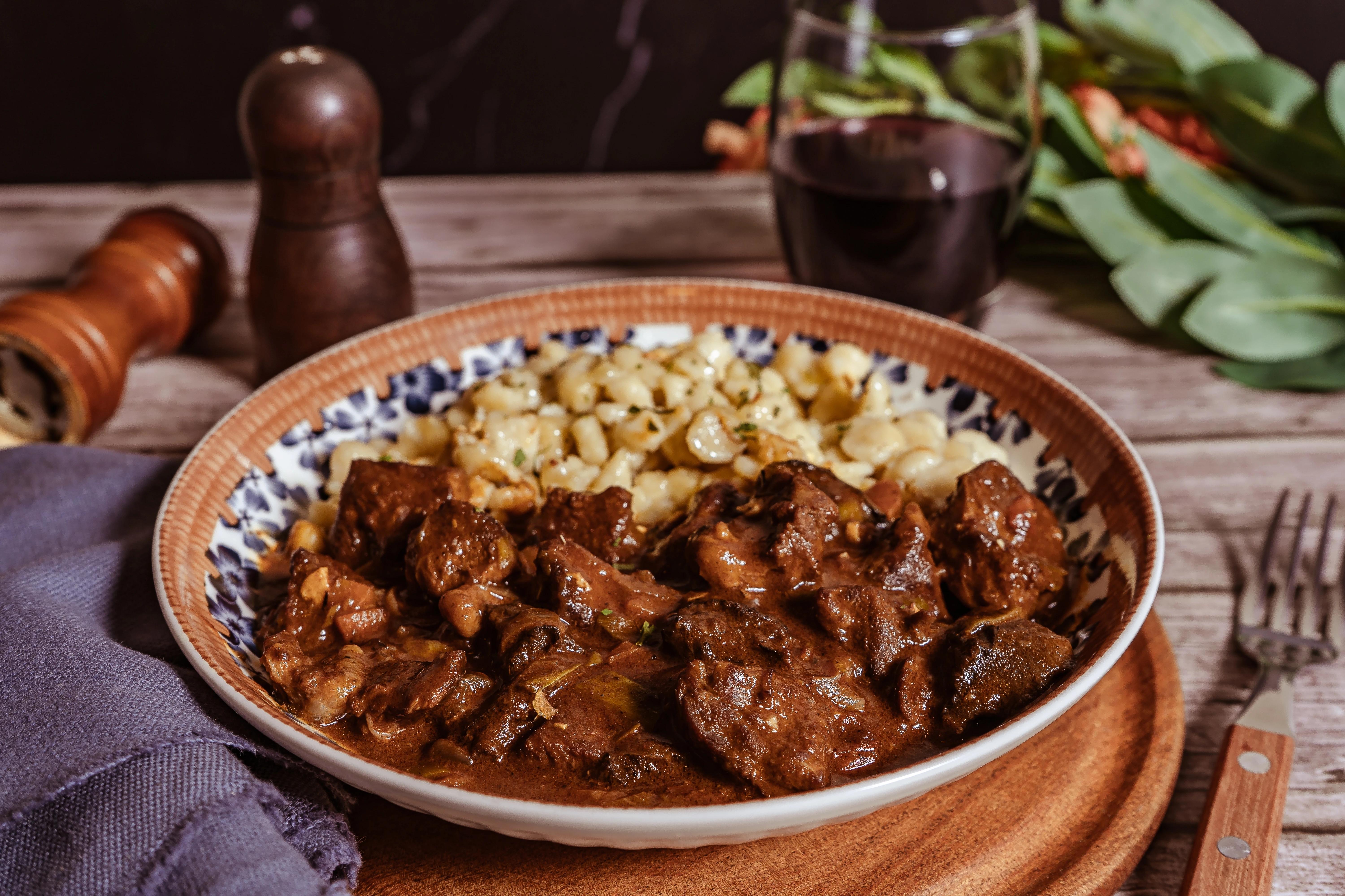 Talíř s porcí maďarského perkeltu s piškotovými knedlíky.