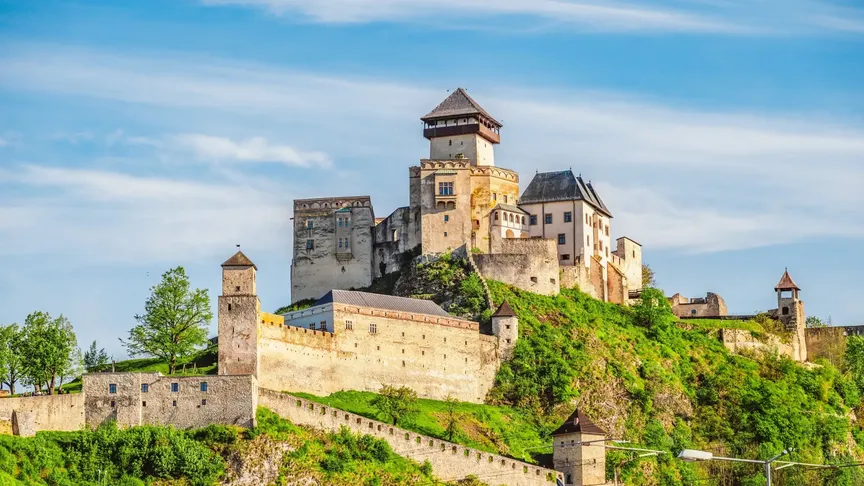 Letecký pohled na Trenčianský hrad. Okolí je plné zeleně.