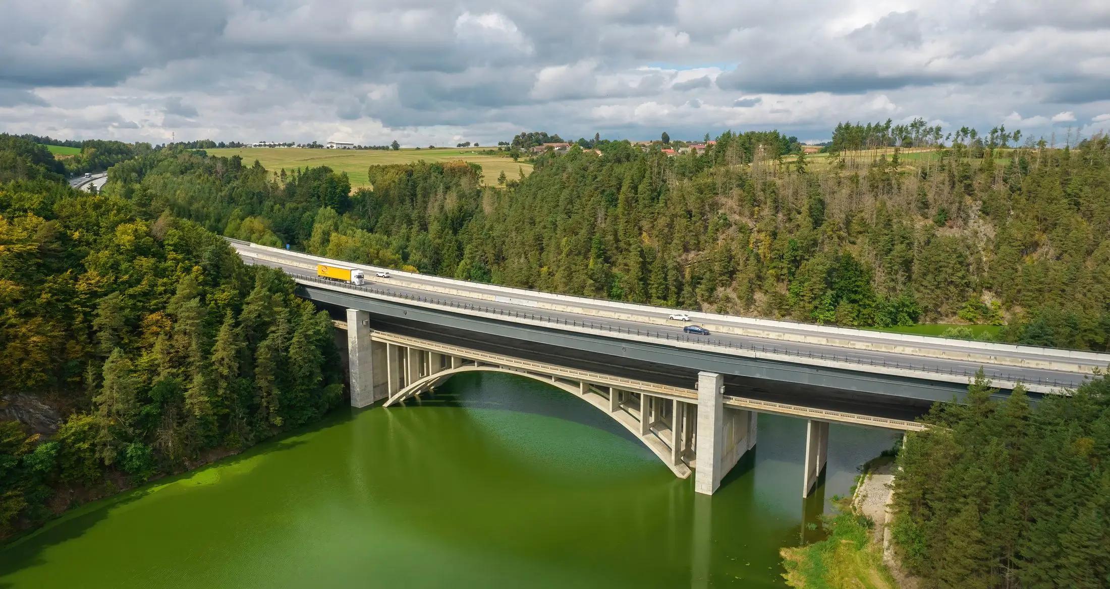 Letecký pohled na Vojslavický most nad řekou. Vidět je i jeho okolní lesy, které jsou zelené.