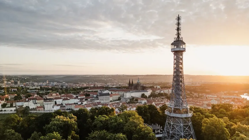 Panoramatický výhled na Petřínskou rozhlednu a na Prahu za ní.