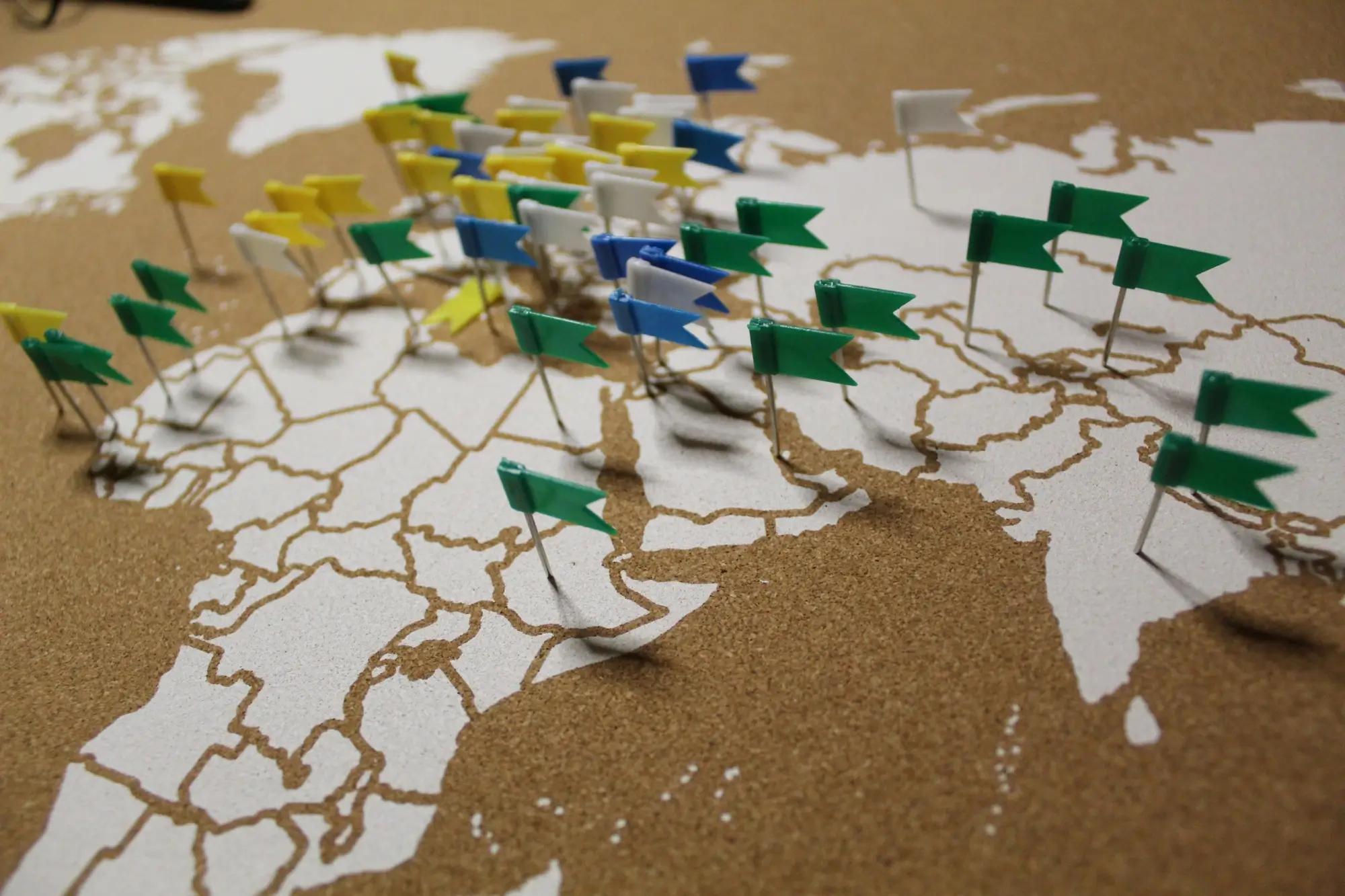 Špendlíky s vlaječkami zapíchnuté do mapy světa